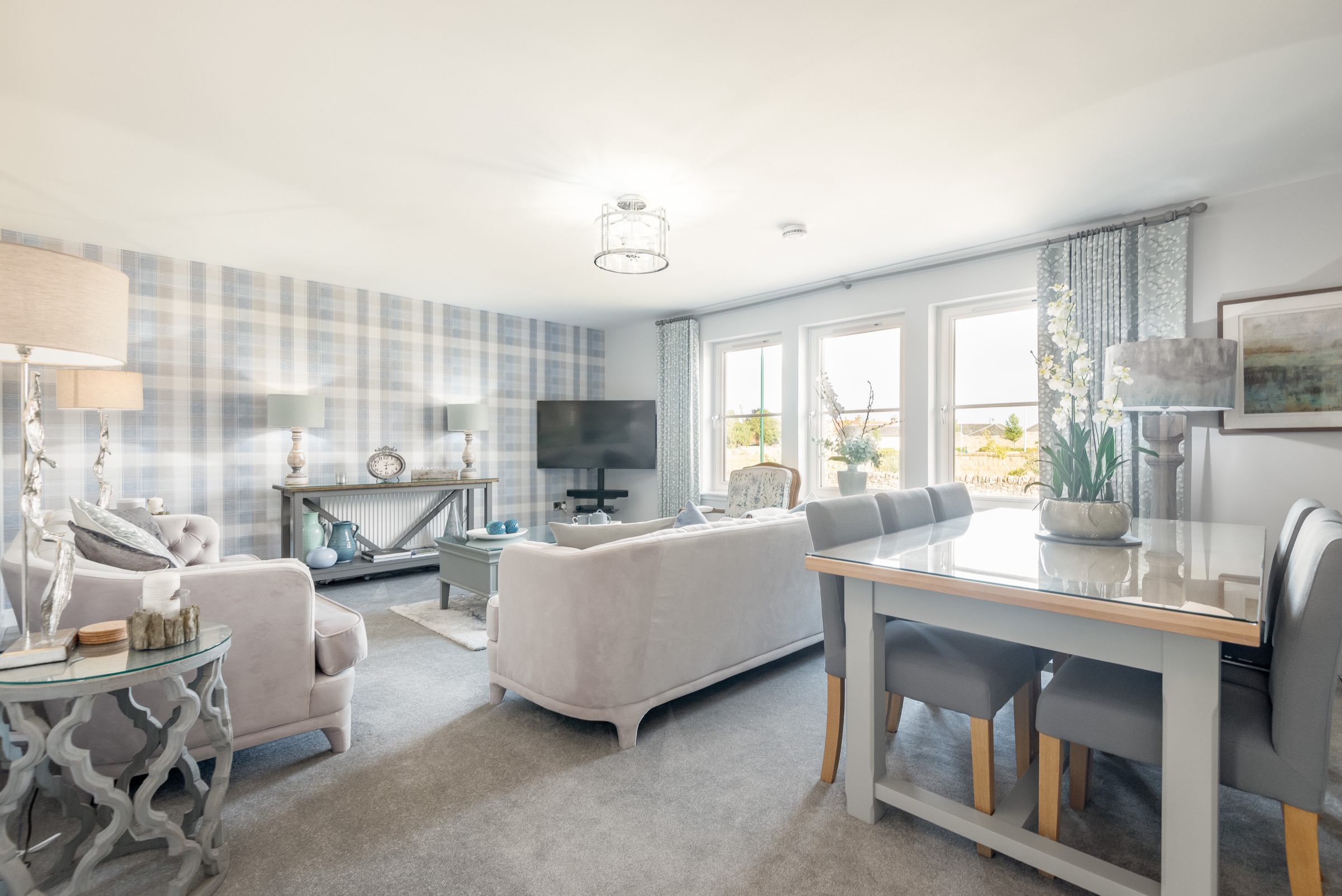 Open-plan living and dining area at Dormie House with a tartan feature wall