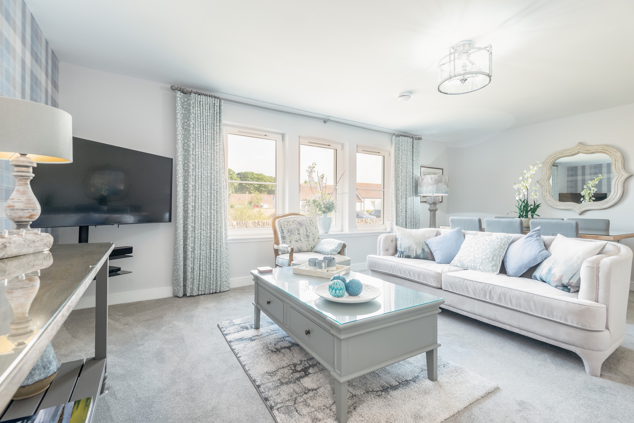 Bright living room at Dormie House with sofas and a wall-mounted TV